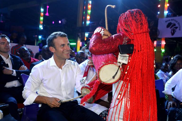 Emmanuel Macron assiste a apresentação de dança típica durante evento com empresários em visita a Abuja, capital da Nigéria