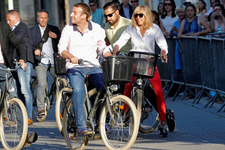 Emmanuel e Brigitte Macron se preparam para andar de bicicleta ao saírem de sua casa em Le Touquet, na França