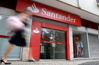 FILE PHOTO: A woman walks past Santander bank branch in Rio de Janeiro
