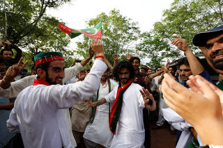Supporters of cricket star-turned-politician Imran Khan, chairman of Pakistan Tehreek-e-Insaf (PTI), celebrate outside his residence in Islamabad, Pakistan, a day after polling in the general election