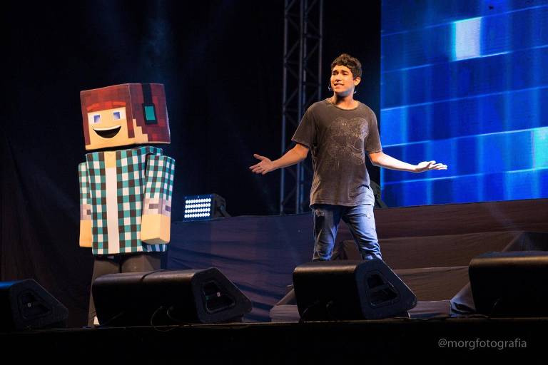 Boneco gigante de Minecraft em um palco com youtuber Marco Túlio