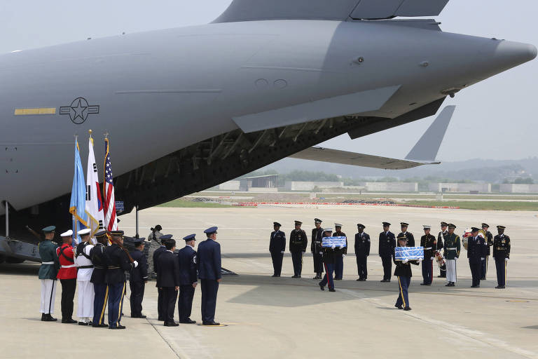 Militares carregam urnas com restos mortais de soldados americanos mortos da Guerra da Coreia, durante cerimônia na base aérea de Osan, em Pyeongtaek (Coreia do Sul) 