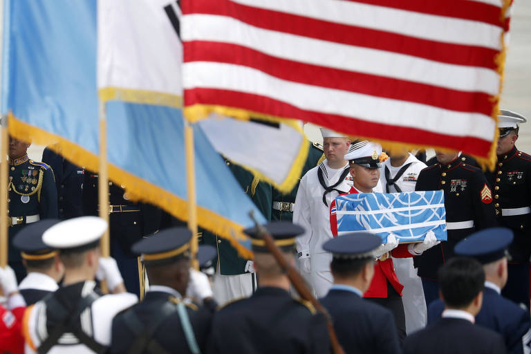 Militar carrega urna com restos mortais de soldados americanos mortos da Guerra da Coreia, durante cerimônia na base aérea de Osan, em Pyeongtaek (Coreia do Sul) 