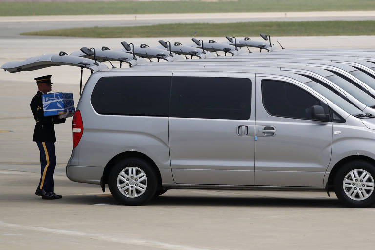 Militar carrega urna com restos mortais de soldados americanos mortos da Guerra da Coreia, durante cerimônia na base aérea de Osan, em Pyeongtaek (Coreia do Sul) 