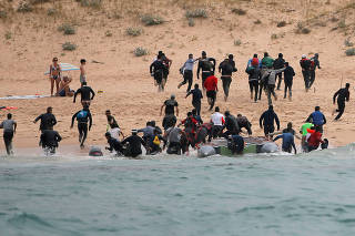 Migrants disembark from a dinghy at 