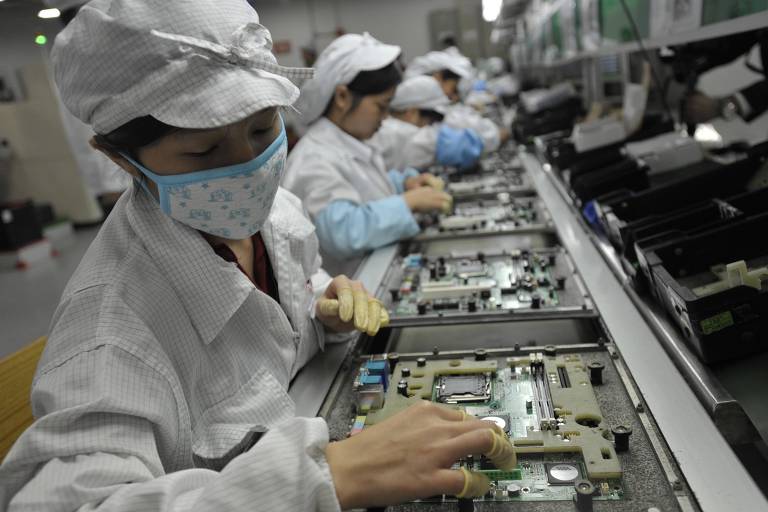Funcionários trabalham na linha de produção da Foxconn, responsável pela produção dos iPhones, em Shenzhen, na China