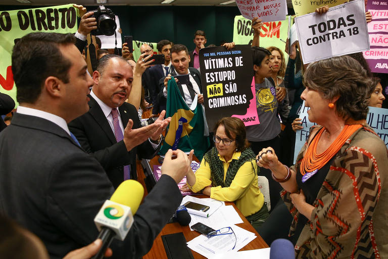 Reunião da Comissão Especial da Câmara dos Deputados para tratar de novas regras para o aborto. Parlamentares contrários e à favor das novas medidas discutiam antes do início da sessão, enquanto manifestantes seguravam cartazes. A deputada Erika Kokay (PT-DF) discutia com o presidente da comissão, o deputado Evandro Gussi (PV-SP), e o deputado Flavinho (PSB-SP)