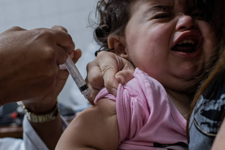 Bebê toma vacina em UBS da zona norte de São Paulo. Um informativo do Ministério da Saúde enviado aos estados, e obtido pela Folha, aponta que o país apresenta situação crítica de abastecimento da vacina meningocócica C, recomendada a bebês para proteção contra meningite. O problema ocorre desde abril, quando foi distribuído quantidade referente a apenas 58% da cota mensal de cada estado, e piorou nos meses seguintes, chegando a atingir apenas 10% da cota em maio, 15% em junho e 36% em julho