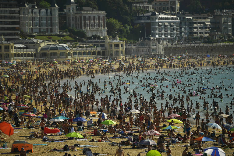 Multidão em La Concha, uma praia no norte da Espanha

