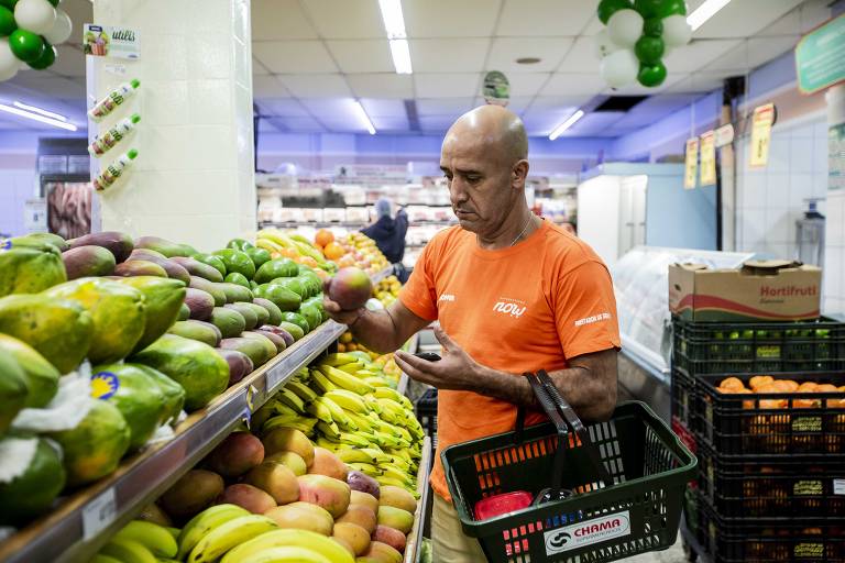 Homem seleciona frutas em supermercado de São Paulo