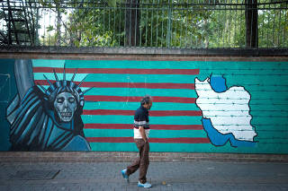 FILE PHOTO: FILE PHOTO: Man walks past anti-U.S. mural in Tehran