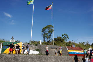 People stand at the border with Venezuela, seen from the Brazilian city of Pacaraima, Roraima state, Brazil