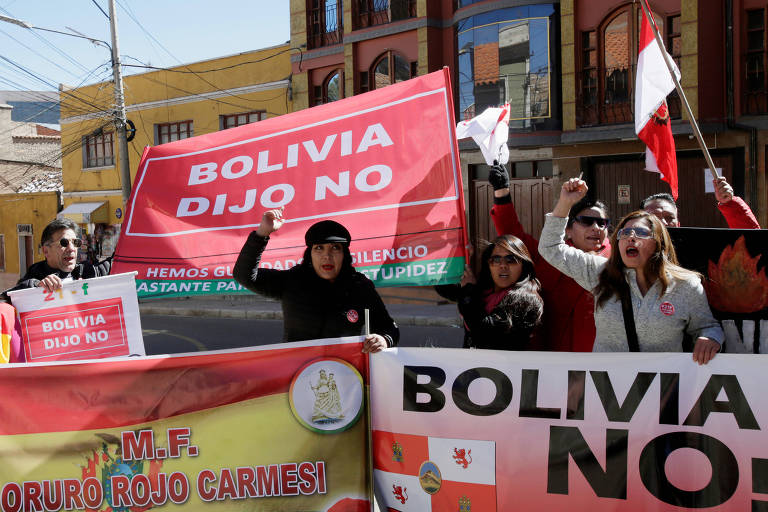 Manifestantes com cartazes com a frase "Bolívia disse não" protestam em Potosí durante o discurso de Evo Morales na cerimônia de comemoração de 193 anos da independência do país 