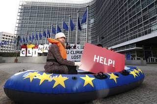 Members of environmental associations gather to demand improvements in climate change and energy models, outside the European Commission headquarters in Brussels