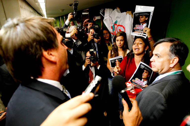 Jair Bolsonaro diante de manifestantes que dão beijo gay feminino em protesto contra o parlamentar na Câmara dos Deputados
