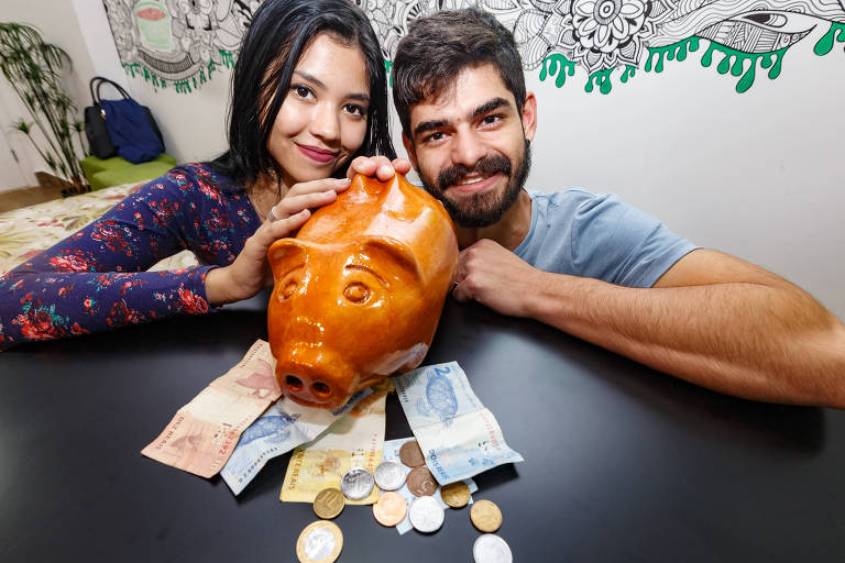 Jhonata Montans e Ana Carolina Ferreira segurando cofre com dinheiro