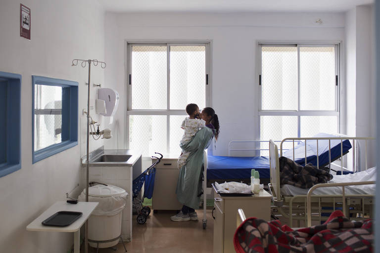Mãe segura criança internada em um quarto no Hospital Municipal Infantil Menino Jesus na Bela Vista, em São Paulo