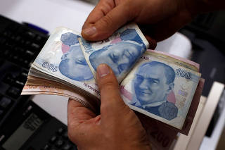 FILE PHOTO: A money changer counts Turkish lira banknotes at a currency exchange office in Istanbul