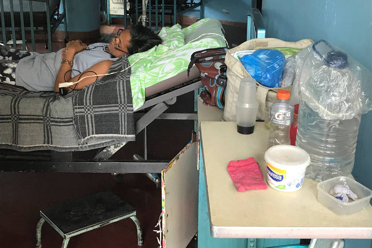 Garrafas usadas para armazenar água ao lado de leito no hospital da Universidade Central da Venezuela; crise de abastecimento já afeta cirurgias na instituição