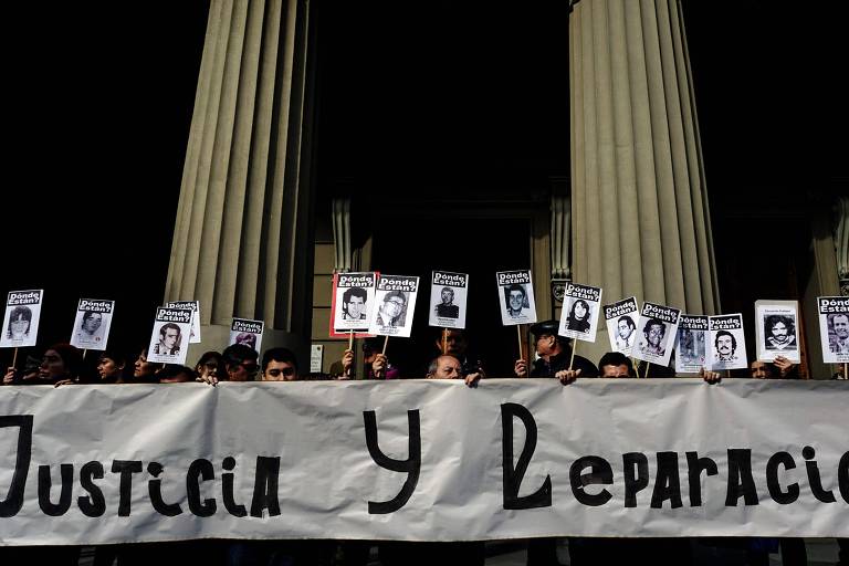 Manifestantes em Santiago carregam cartazes de pessoas desaparecidas durante a ditadura de Augusto Pinochet 