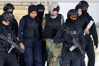 Vietnamese Doan Thi Huong is escorted as she leaves the Shah Alam High Court