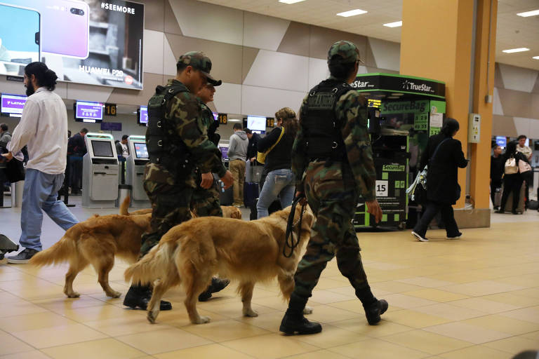 Polícia peruana com cães farejadores passam pelo saguão do aeroporto de Callao, próximo a Lima, o principal do país, após as ameaças de bomba 