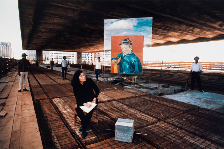 Lina Bo Bardi na construção do Masp, na década de 1960, em frente à reprodução de "O Escolar"