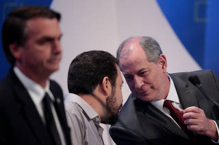 Presidential candidate Guilherme Boulos talks with Ciro Gomes next to Jair Bolsonaro before a television debate in Osasco