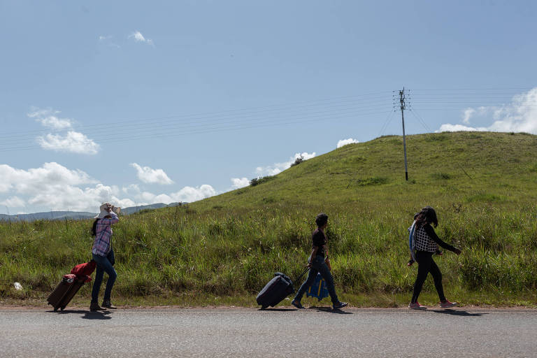 Venezuelanos caminham em direção à fronteira com o Brasil