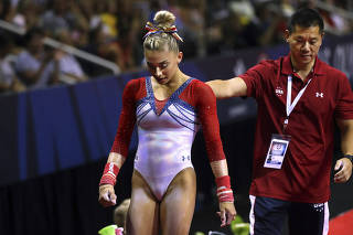 Ashton Locklear, left, and her coach Qi Han at the 2016 United States Olympic Trials with one of his gymnasts in San Jose, Calif.
