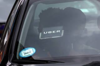 FILE PHOTO:    An Uber logo is seen on a car a as it car drives through Times Square in New York City
