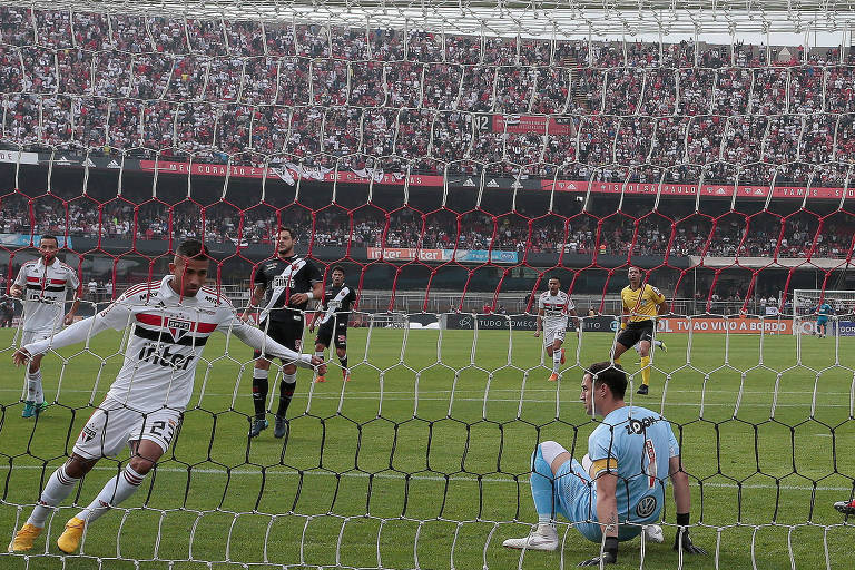 Jogador do São Paulo, Rojas, comemora gol com os braços abertos, ao lado do goleiro do Vasco