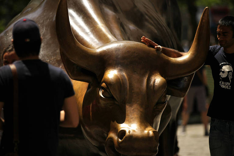 Pessoas tiram fotos com o Touro de Wall Street, em Nova York