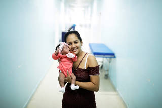 Irene, 23, a Venezuelan woman from Santa Elena city, holds her six-day-old baby Ashlei at a maternity hospital in Boa Vista