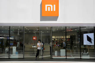 FILE PHOTO: A customer walks out of a Xiaomi store in Beijing
