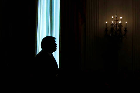 U.S. President Donald Trump is silhouetted in a window of the East Room as he participates in a ceremony awarding a Medal of Honor posthumously to Air Force Technical Sergeant John A. Chapman at the White House in Washington, U.S., August 22, 2018.  REUTERS/Leah Millis ORG XMIT: WAS469