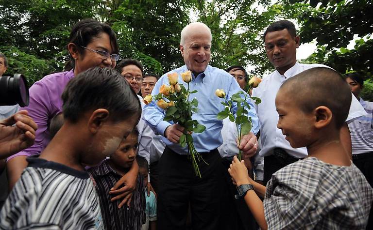 O senador John McCain recebe flores de crianças com HIV em hospital em Yangon (Mianmar) 