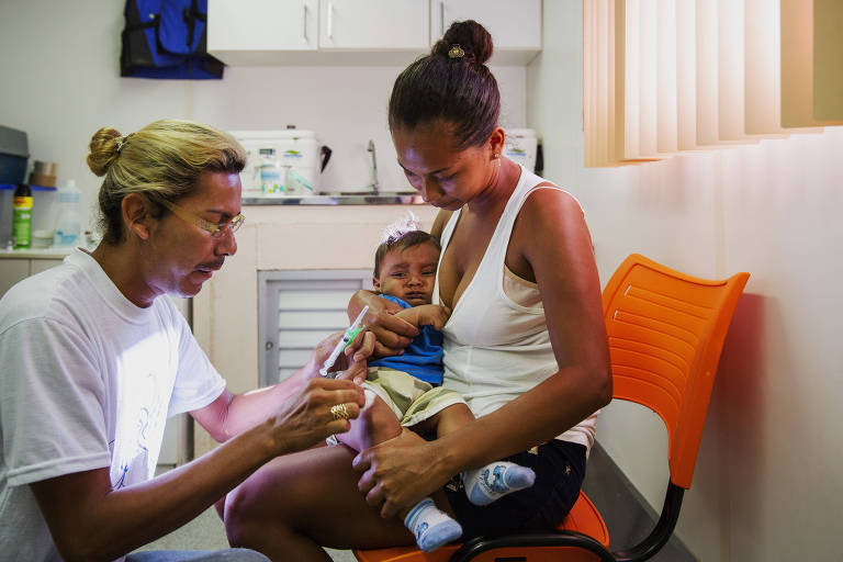 O técnico de enfermagem Mauro Coutinho aplica vacina em Rodrigo Caio Brasil, 7 meses, no colo de sua mãe Rosineti Brasil, 25, na Unidade Básica de Saúde Fluvial em Borba, no Amazonas