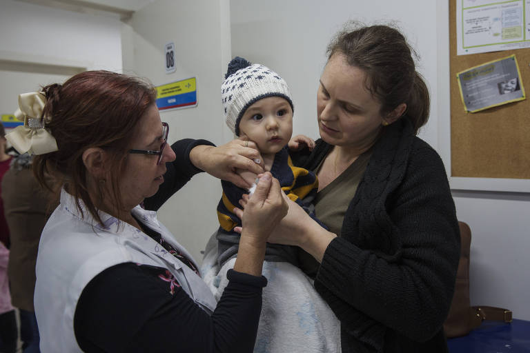 Matheus Altenhofen Ribeiro é vacinado no colo de sua mãe Tania Altenhofen Ribeiro no Centro de Saúde Itacorubi em Florianópolis.