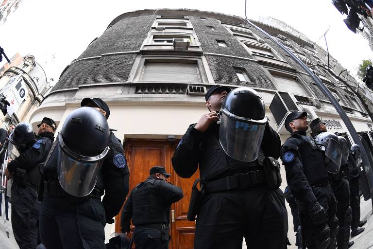 Policiais guardam a entrada do prédio onde fica o apartamento da ex-presidente Cristina Kirchner na Recoleta, em Buenos Aires, que foi alvo de buscas na quinta (23)