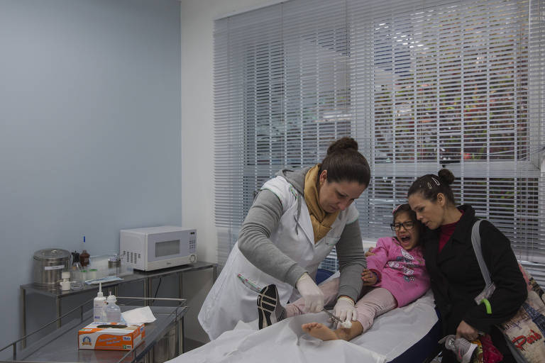 A enfermeira Izabel Martendal faz um curativo em uma moradora da região no Centro de Saúde Saco Grande em Florianópolis. 