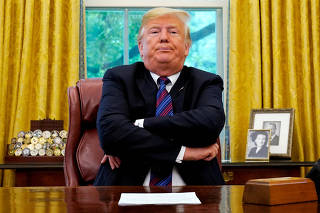 FILE PHOTO:    President Trump sits behind his desk as he makes announcement about a bilateral trade deal with Mexico at the White House in Washington