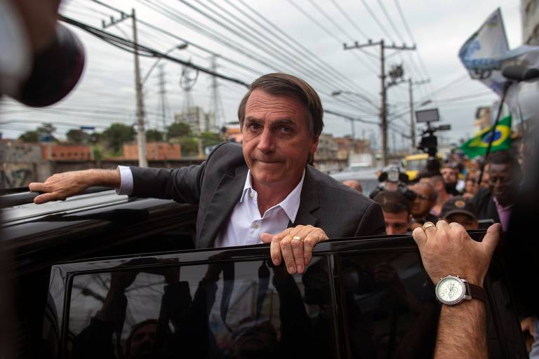 Jair Bolsonaro entra num carro durante campanha no mercado de Madureira, no Rio de Janeiro