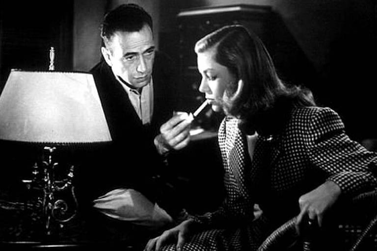 Humphrey Bogart prepara-se para aprender a assobiar com Lauren Bacall no filme 'Uma Aventura na Martinica'
