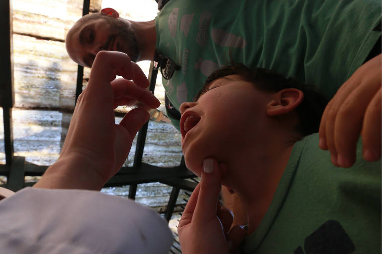 Gustavo Fuser com seu filho Daniel, em posto-volante no Parque Ibirapuera, na zona sul de São Paulo; este sábado (1º) foi o segundo 'dia D' da campanha de vacinação contra poliomielite e sarampo, uma tentativa do Ministério da Saúde aumentar as taxas de imunização de crianças entre 1 e 5 anos 