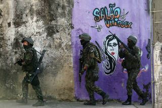 Brazilian soldiers patrol near the Chatuba slum in Rio de Janeiro