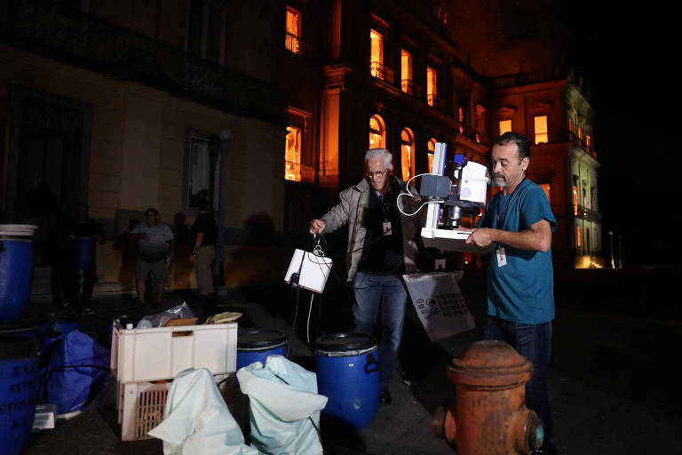 Colaboradores resgatam itens durante um incêndio de grandes proporções que atingiu o Museu Nacional do Brasil, no Rio de Janeiro