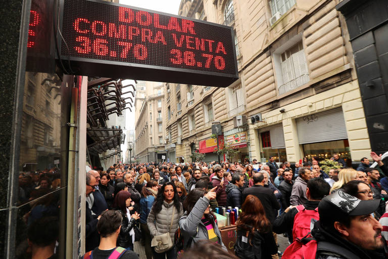 Funcionários públicos protestam em frente a uma casa de câmbio em Buenos Aires 