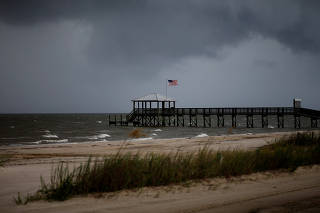 Storm clouds loom over a pier as Tropical Storm Gordon approaches in Waveland