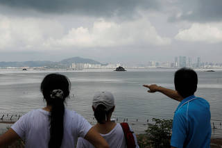 A tourist points China's Xiamen from a former military fort, ahead of the 60th anniversary of Second Taiwan Straits Crisis against China, on Lieyu island, Kinmen county